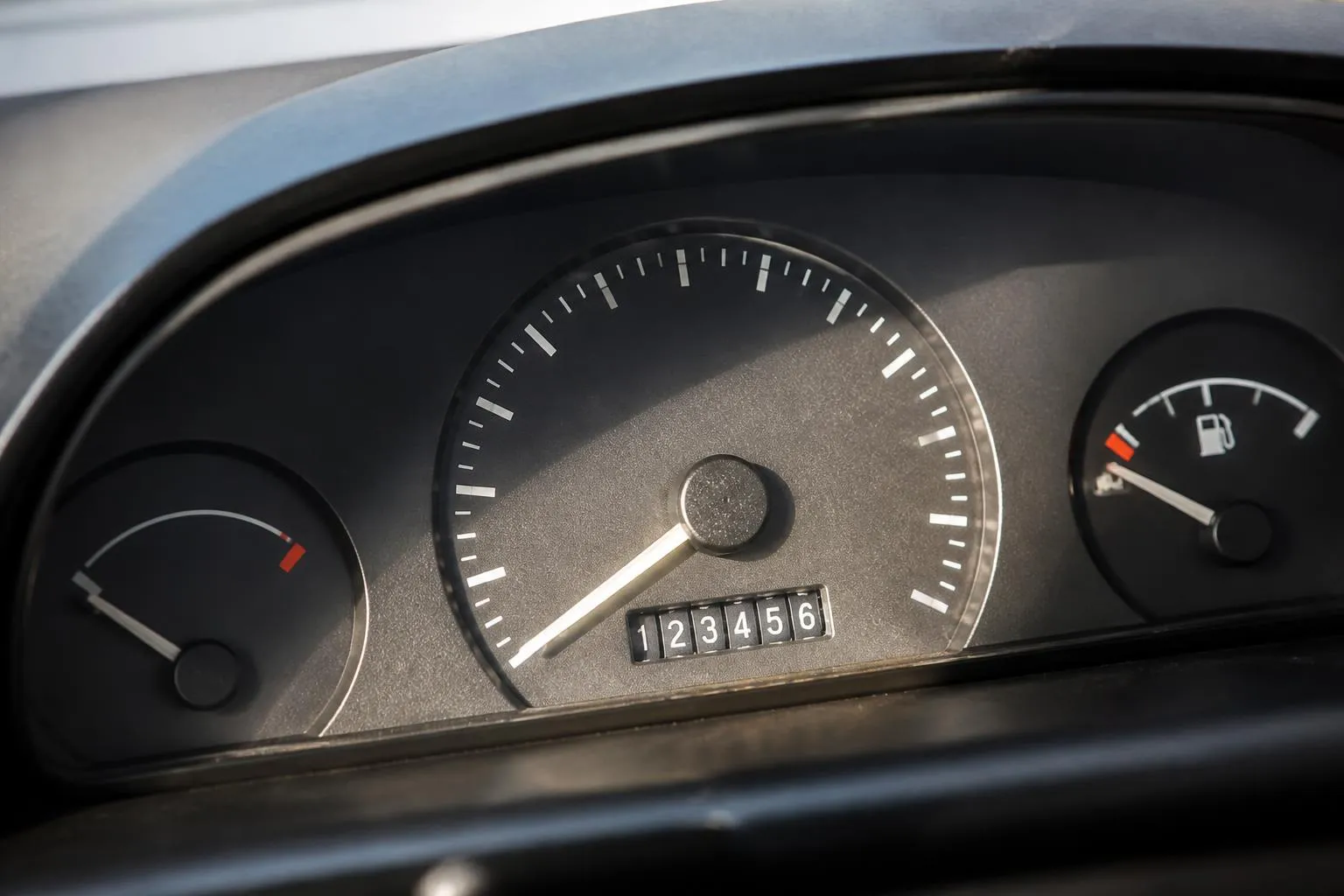 Compteur kilométrique d’une voiture, aiguille au repos, chiffres du totalisateur bien lisibles.